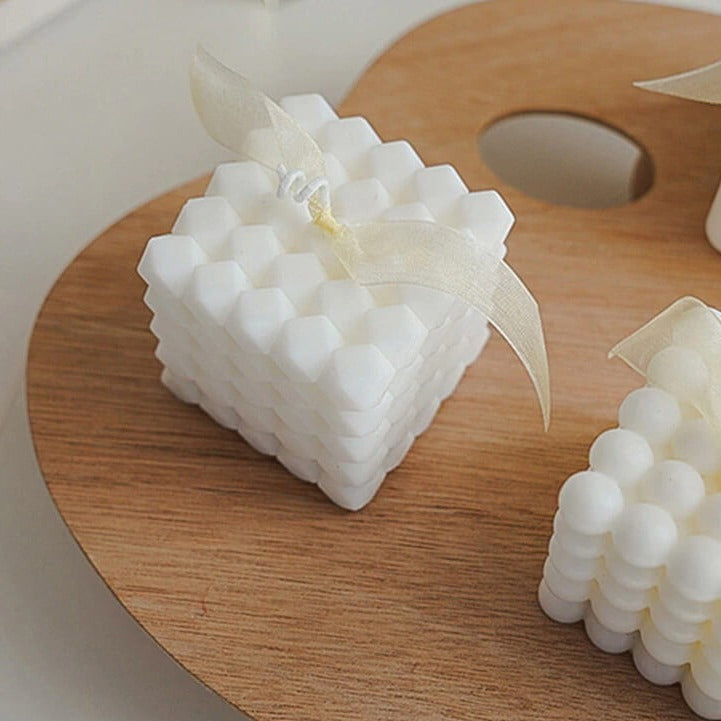 White honeycomb candle with ribbon on wooden palette