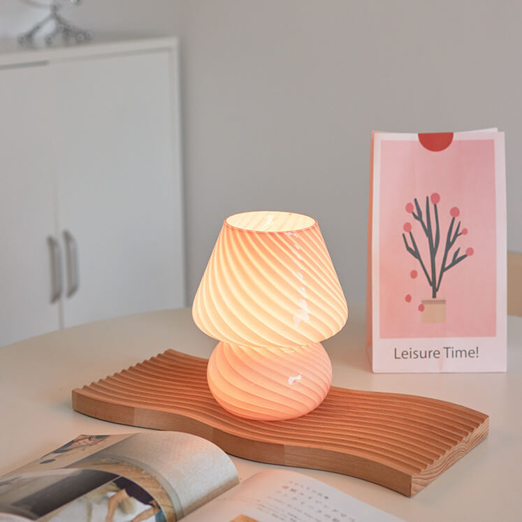 Pink mushroom lamp on a wooden tray.