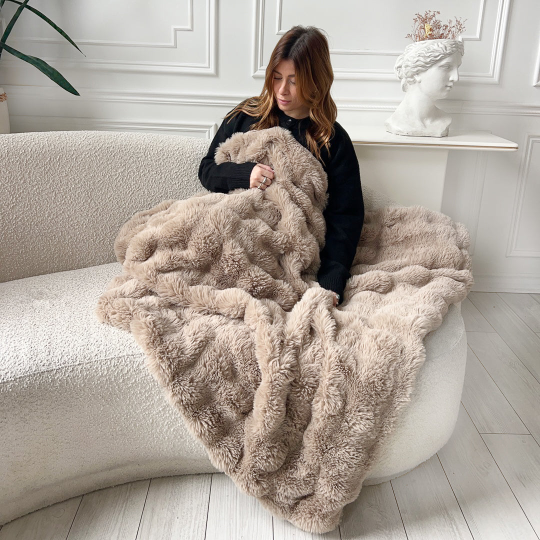Woman with brown plush blanket on sofa